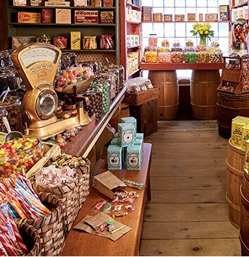 Shelves stocked with glass jars, baskets, and tins of vintage candy.