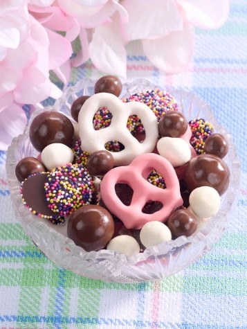 Assorted chocolate covered candies in dish.
