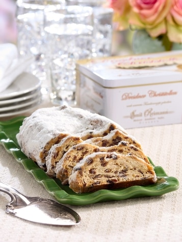 Sliced Stollen loaf on tray with white tin.