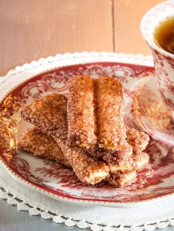 Stack of Buttery Cinnamon Sticks on Plate with Tea