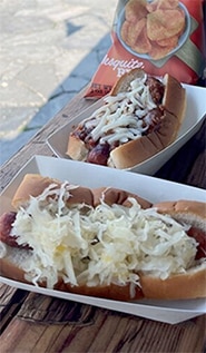 Hot dog with sauerkraut and another with chili and cheese.